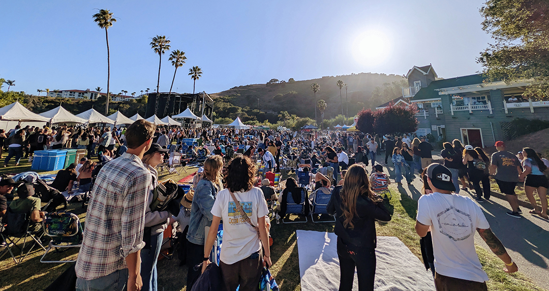 Full crowd at Avila Beach throwing up peace signs