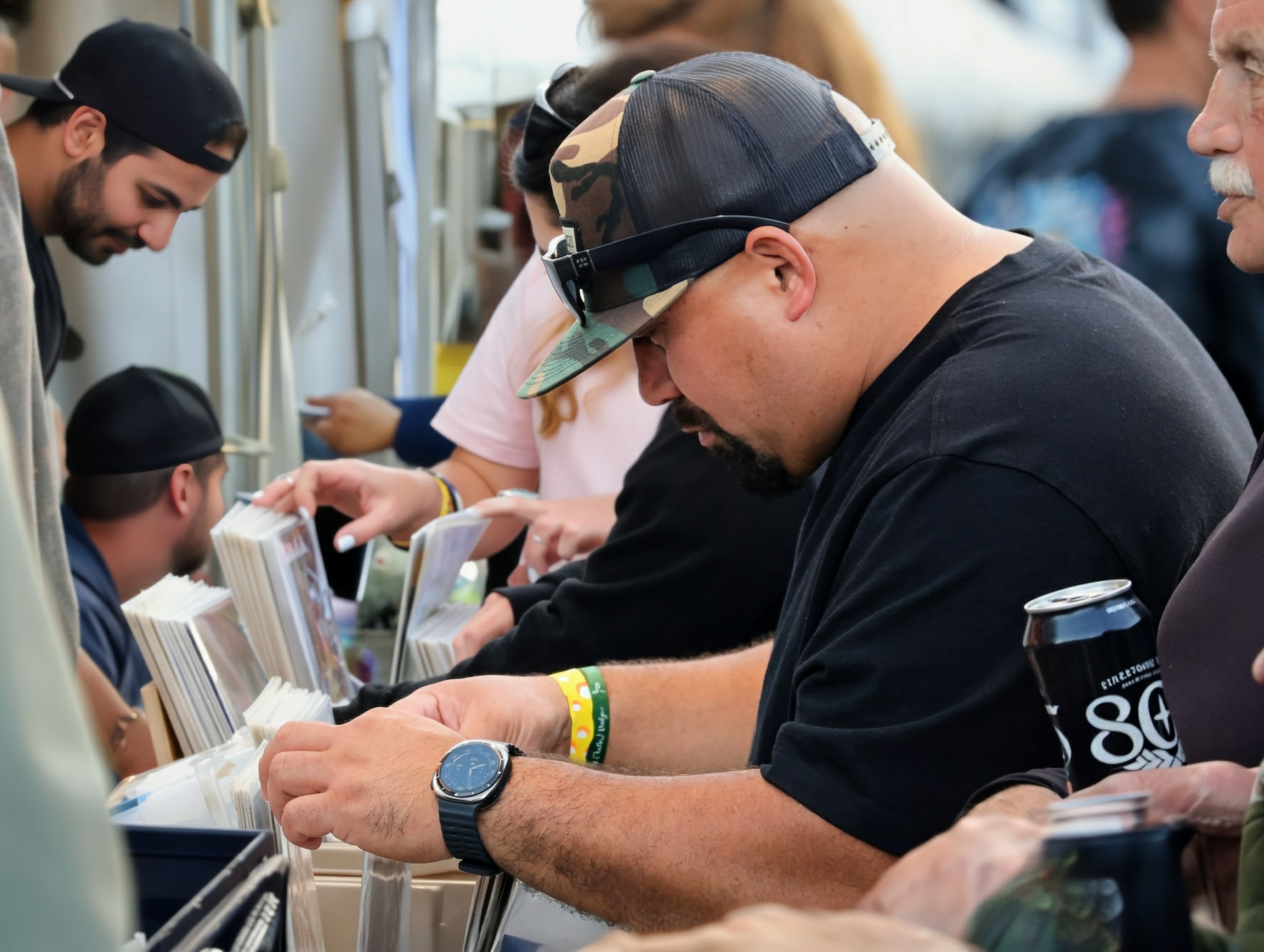 Fan flipping through vinyl and prints at a vendor tent