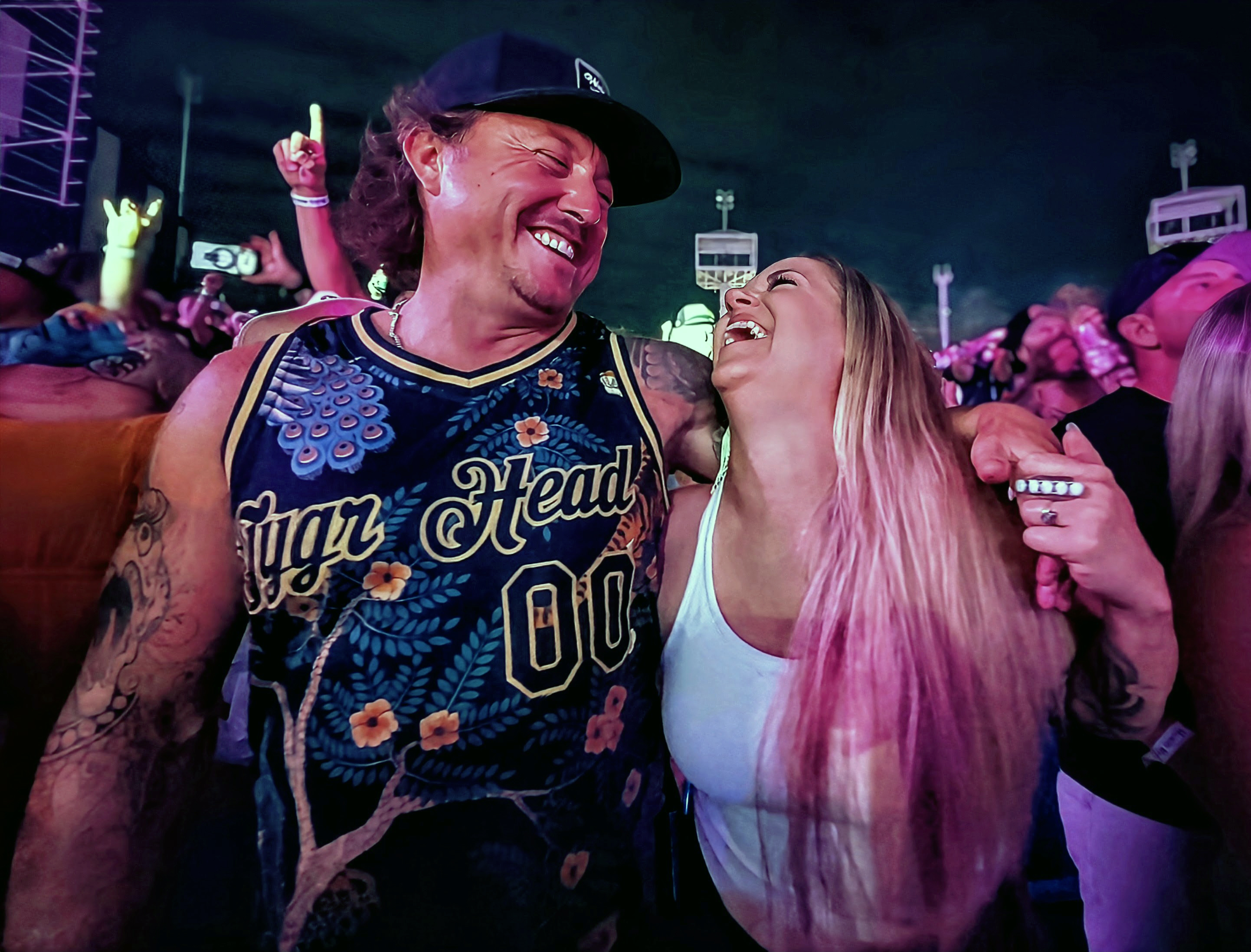 A smiling couple laughing together in the crowd during The Elovaters